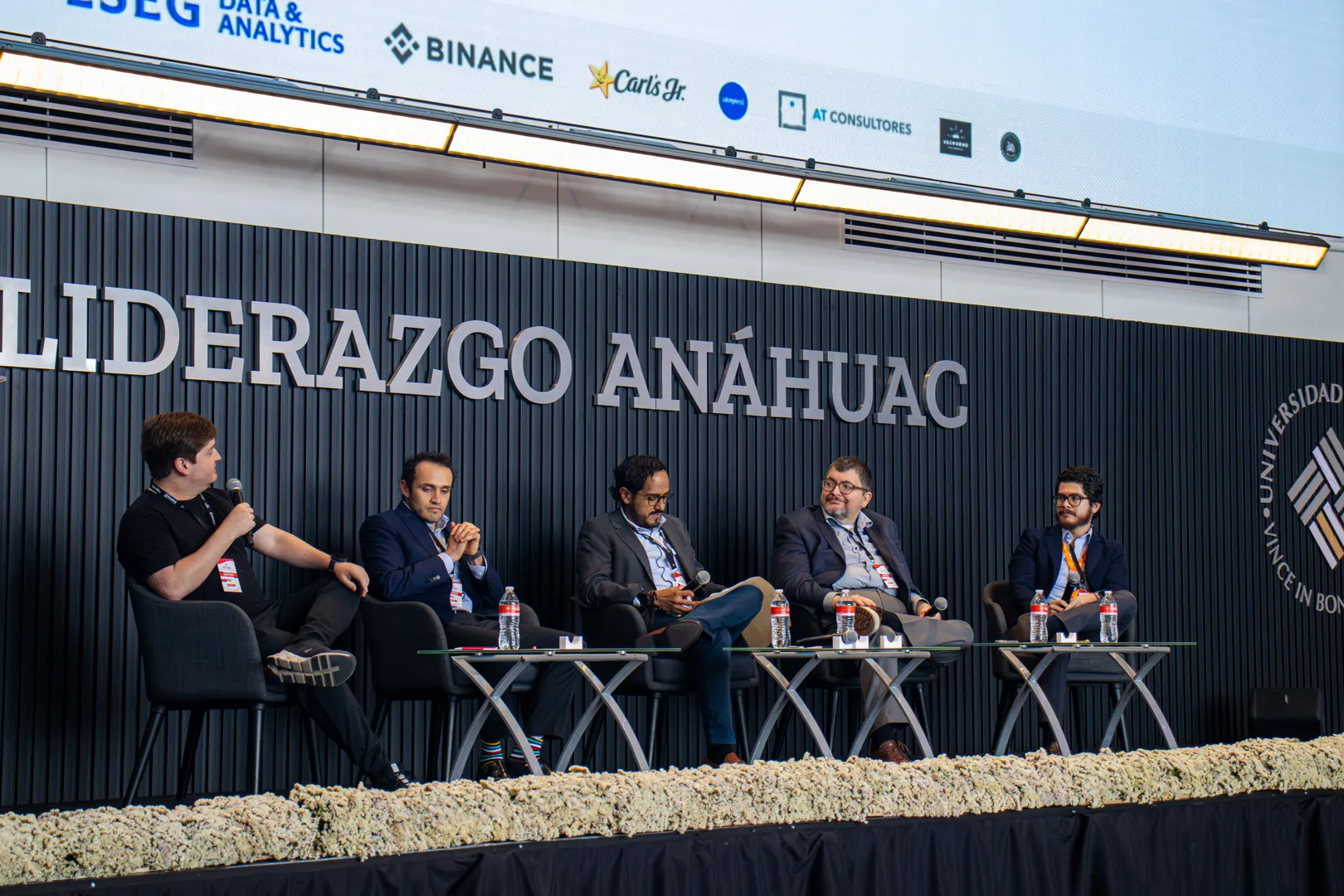 Cinco panelistas conversan en el escenario.