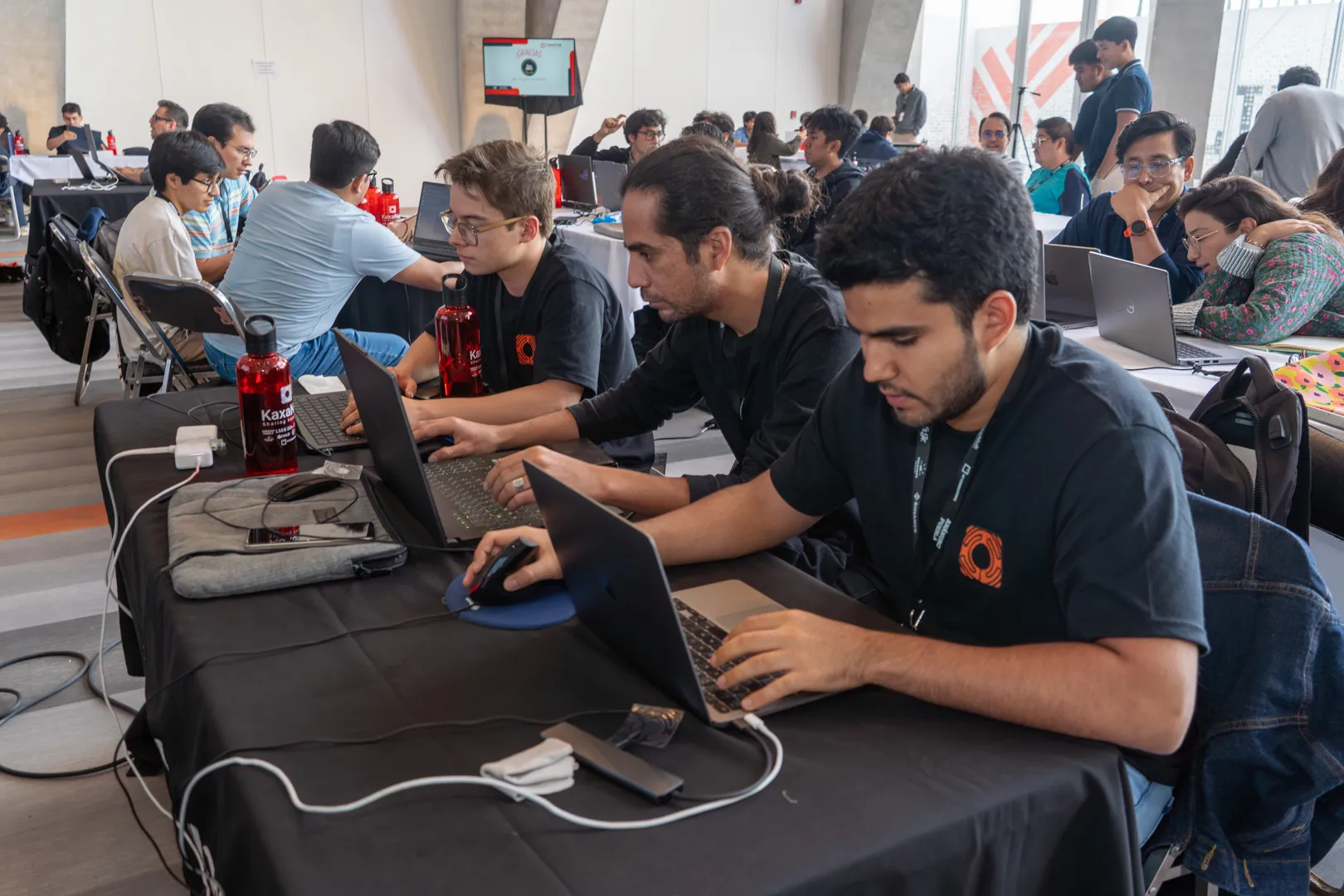 Participantes programan en mesas compartidas.